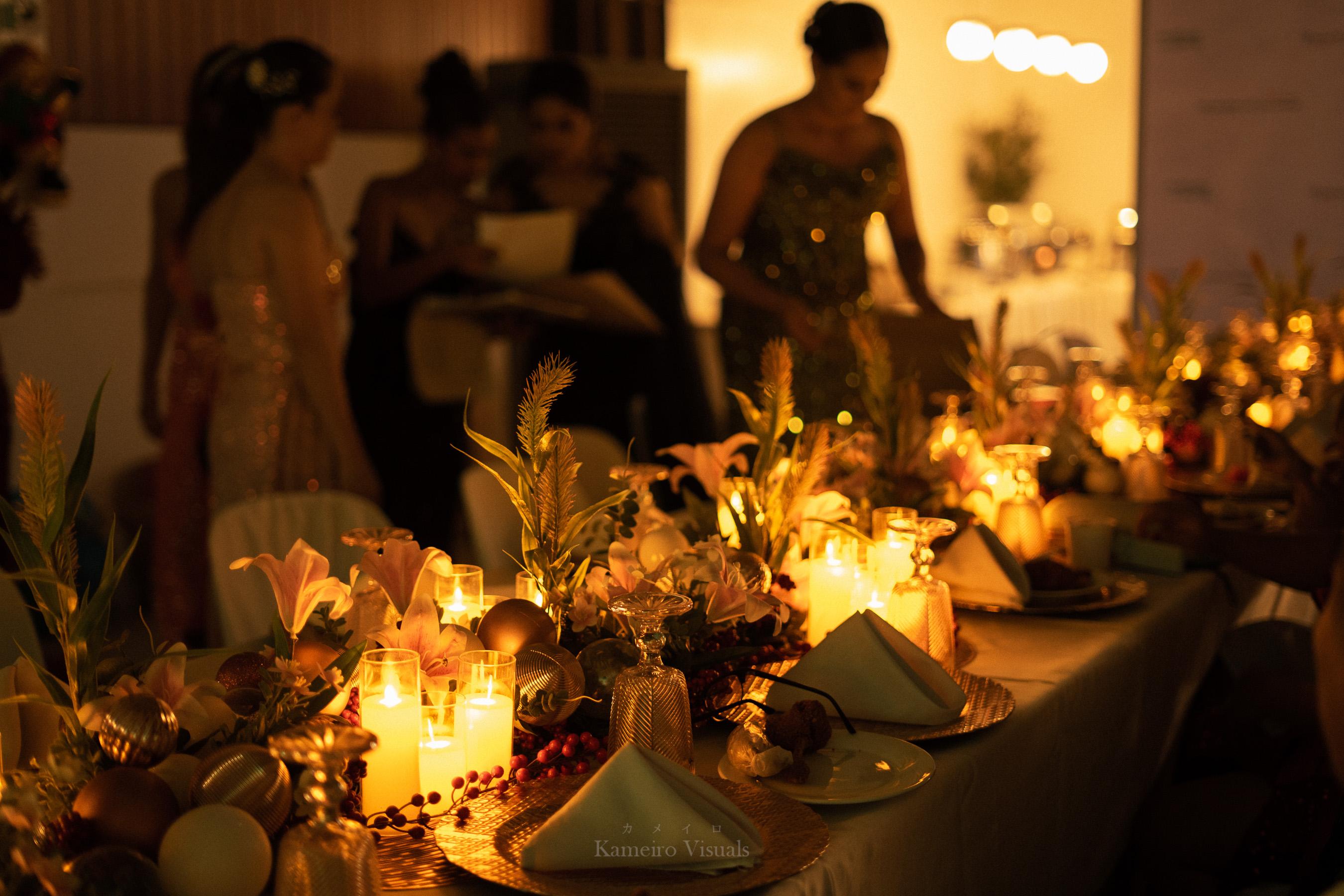 A candlelit event table with guests and warm evening light.